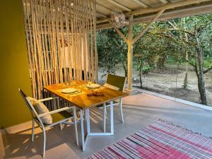 a dining room with a table and chairs and a large window at Suíte Tiê com vista para o lago in Ubatuba