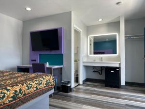 Habitación de hotel con cama, lavabo y espejo en Fountain Inn Motel - Alhambra, Los Angeles, en Alhambra
