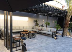 a patio with white couches and tables and a table at Lyva chalet in Al Rama