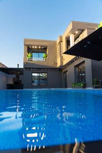 a house with a swimming pool in front of a house at Lyva chalet in Al Rama