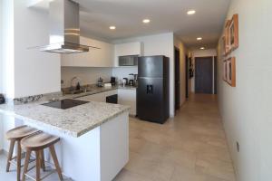 uma cozinha com uma geladeira preta e um balcão em Beautiful and New Bahía Serena Condominium em Isla Cardones