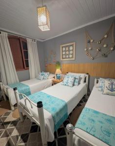 two beds in a room with blue and white at Casa Luke Paraty in Paraty +53 photos