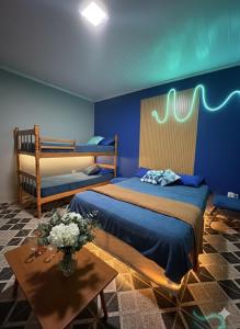 a bedroom with two beds and a table with flowers on it at Casa Luke Paraty in Paraty