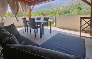 a living room with a couch and a table with chairs at Amazing Apartment In Baska With Swimming Pool in Draga Bašćanska +6 photos