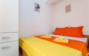 a bedroom with a bed with yellow and orange sheets at Amazing Apartment In Baska With Swimming Pool in Draga Bašćanska