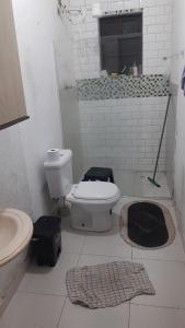 un baño con inodoro y lavabo en Pousada Luanda, en Peruíbe