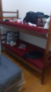 Litera roja en una habitación en Pousada Luanda, en Peruíbe