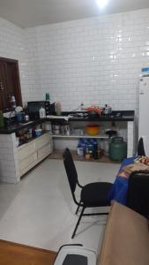 Una cocina con una mesa y una silla en una habitación. en Pousada Luanda, en Peruíbe