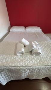 a white bed with two towels on it at Apartamento Canoas RS in Canoas +9 photos