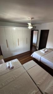 two beds in a room with white cabinets at Apartamento Canoas RS in Canoas