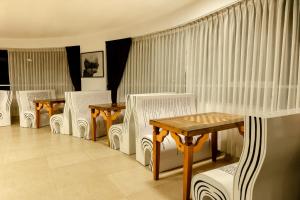 a room with white chairs and tables and curtains at Hacienda del Valle Sagrado in Urubamba
