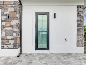 a white house with a black door at Elegant Naples Studio with Huge Bathroom in Naples +16 photos