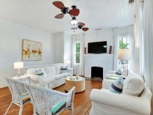 a living room with white furniture and a fireplace at Coast A While in Tybee Island