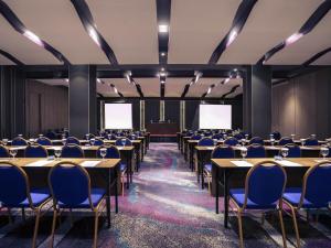 a conference room with tables and chairs and two screens at Mercure Jakarta Sabang in Jakarta +80 photos