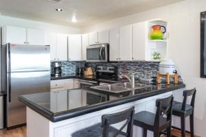 a kitchen with white cabinets and a stainless steel refrigerator at Sonoran Spa W404 in Campo del Medio