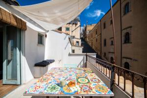 a table on the balcony of a building with a view at Loft con terrazzo sulla Scala in Caltagirone