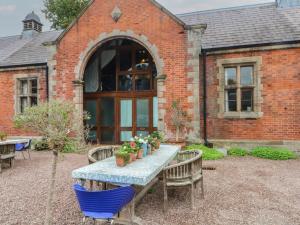 a table and chairs in front of a brick building at Diamond Lodge in Ingestre
