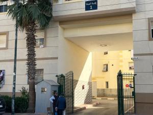 three people standing in front of a building with a gate at Premium Stay Apartment, Rabat in Sale