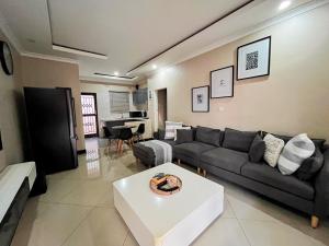 a living room with a couch and a table at Palms & Pebbles Home in Lilongwe