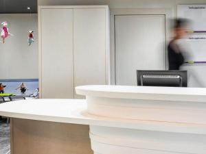 a white counter in a room with people in the background at ibis Styles Meaux Centre in Meaux