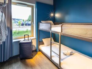 a room with two bunk beds and a window at ibis budget Epinal in Épinal
