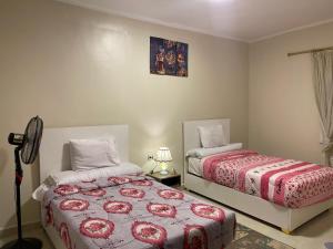 Un dormitorio con dos camas y una lámpara. en ABAr, en Banī Ghālib 31 fotos más