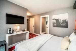 a hotel room with a bed and a flat screen tv at Lexen Hotel - Hollywood in Los Angeles