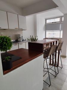 a kitchen with white cabinets and a wooden counter top at Departamento sobre la costanera in Corrientes +4 photos