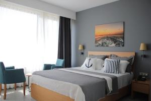 een slaapkamer met een groot bed met blauwe muren bij Port Marina Hotel in Karatas