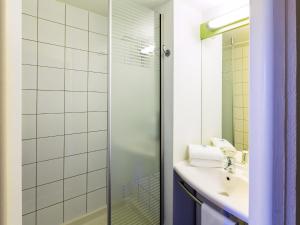a bathroom with a sink and a shower at Ibis budget Béziers Est Mediterranée A9 / A75 in Béziers +37 photos