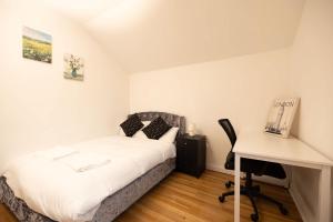 Un dormitorio pequeño con una cama y un escritorio. en Knightswood, en Scotstoun West Station