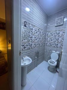 un baño con inodoro y lavabo en ABAr, en Banī Ghālib