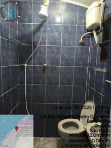a bathroom with a toilet and a phone on the wall at Chalé da Elba in Ilhabela