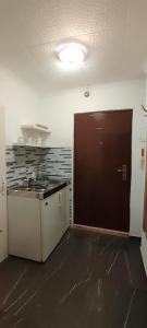 a kitchen with a sink and a brown door at Republic square apartment in Belgrade +5 photos