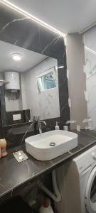 a bathroom with a white sink and a mirror at Republic square apartment in Belgrade