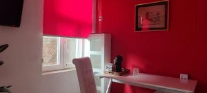 a room with a red wall with a table and a window at Republic square central in Belgrade