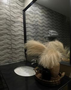 a bathroom with a sink and a basket with feathers at Luxury Lodge in Rawalpindi