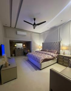 a bedroom with a bed and a ceiling fan at Luxury Lodge in Rawalpindi