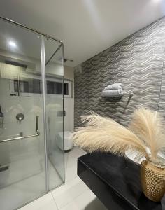 a bathroom with a glass shower and a black table at Luxury Lodge in Rawalpindi