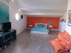 1 dormitorio con cama y pared de color naranja en Marseille et sa Campagne Chic, en Allauch