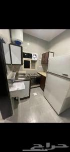 a kitchen with a white refrigerator and a sink at الفرعاء ابها in Al Maḩshūsh