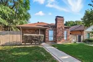 een stenen huis met een hek en een tuin bij Vibrant 3BR Dallas Home, Near DFW, With Family-Friendly Amenities in Irving