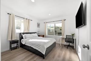 a bedroom with a bed and a flat screen tv at Spacious 4BR Retreat in Pomona with Sauna and Hot Tub in Pomona