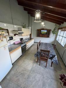 a kitchen with a table with chairs and a refrigerator at Sierra Chica in Alta Gracia +7 photos