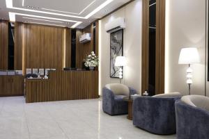 a lobby with blue chairs and a reception desk at راديكس ميلينيوم Radix Millennium in Ar Ruwanah