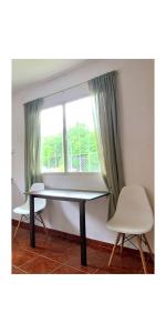 a table and a chair in front of a window at Apart Sierras Chicas in Río Ceballos