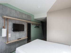 a bedroom with a bed and a flat screen tv at ibis budget Senlis in Senlis +39 photos