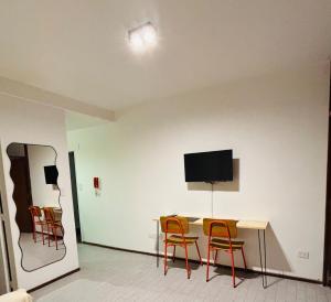 a room with a table and chairs and a tv on the wall at Minisuite Estación Ramos Mejía in Ramos Mejía