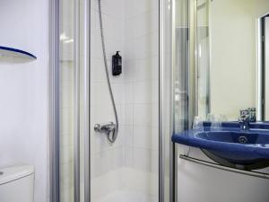 a bathroom with a blue sink and a shower at ibis budget Arles Sud Fourchon in Arles +34 photos