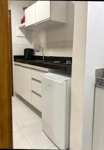 a white kitchen with a sink and a dishwasher at Apartamento Paraíso Refúgio - Manoah Beach Flats in Maragogi